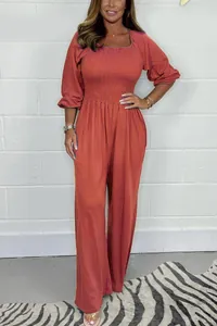 Stylish burnt orange casual smocked jumpsuit with long puff sleeves and wide leg fit.