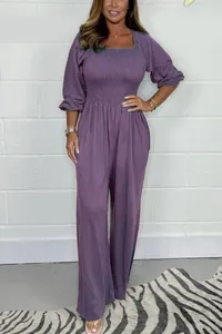Purple smocked wide leg jumpsuit featuring puff sleeves and square neckline details