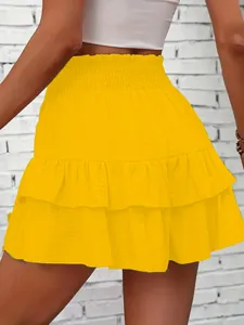 Back view detail of vibrant yellow tiered ruffle mini skort featuring high smocked waist