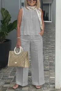 Full-body view of a woman wearing a light grey sleeveless cotton linen set with wide-leg pants.