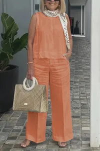 Outdoor full body shot of a chic orange sleeveless cotton linen set featuring wide-leg pants