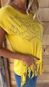 Close-up of yellow round neck t-shirt featuring rhinestone stars and stylish fringe hem