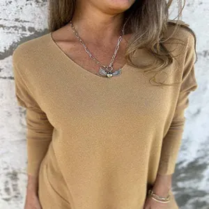 Détail d'un pull en maille col V couleur chameau sur un modèle avec une texture