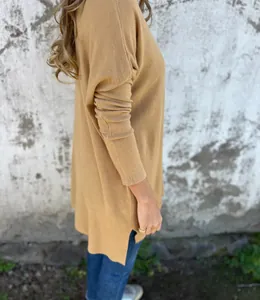 Vue latérale d'un pull en maille col V ample couleur camel avec fente latérale.