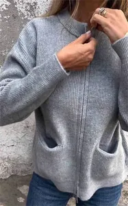 Detalle de la textura de una chaqueta de punto gris con cuello alto y cremallera