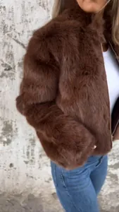 Close-up of a cozy brown faux fur jacket with high collar and front zipper detail