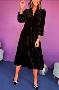 Full view of black V-neck velvet tiered midi dress with long sleeves in a studio setting