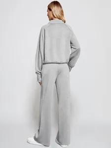 Back view of a women's gray two-piece tracksuit with zipper sweatshirt and wide-leg pants.