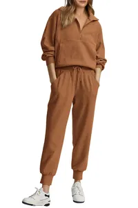Detailed view of women's ribbed half-zip sweatshirt and matching jogger lounge set in rust