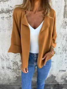 Dettaglio di un cardigan aperto casual in finto camoscio marrone caramello con risvolto.