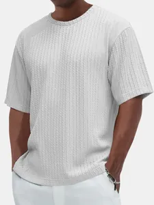Détail montrant la texture en maille torsadée du t-shirt blanc à col rond pour hommes