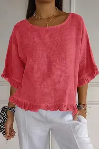 Détail d'une blouse en lin rose corail avec des volants féminins et un col rond