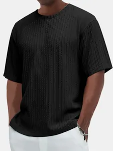 Détail en gros plan du tissu texturé sur un t-shirt noir à manches courtes pour hommes