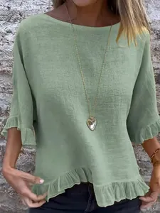 Détail d'une chemise en coton et lin vert clair avec ourlet à volants et col rond
