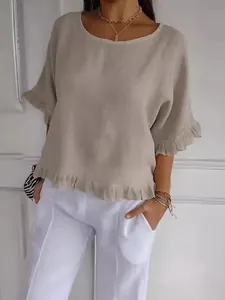 Détail rapproché du chemisier en coton lin à col rond avec ourlet à volants pour femme