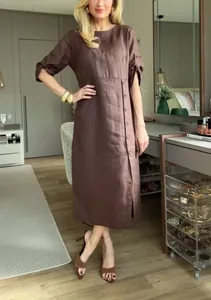 Elegante modella che indossa un abito midi casual in cotone e lino marrone bottonato