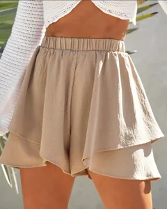 Detailed macro shot of women's beige tiered ruffle shorts featuring a stretchy elastic waist.