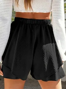 Close-up of black elastic high-waist shorts with layered hem and textured fabric.