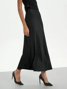 Detail view of an elegant high-waisted black satin midi skirt with a glossy finish.