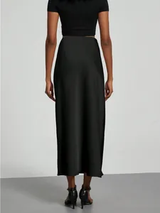 Elegant black satin midi skirt with glossy finish, back view showing high waist fit.
