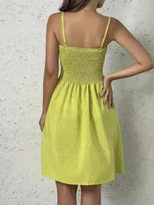 Vue arrière détaillée d'une robe d'été courte vert citron à pois avec un dos smocké élégant.