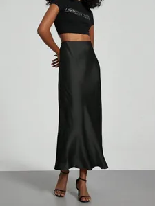 Detail view of a black satin midi skirt with elegant glossy finish and high waist
