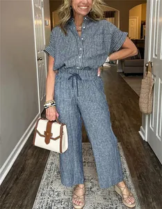 Donna con completo a righe blu composto da camicia a maniche corte e pantaloni larghi