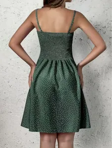 Vue arrière d'une mini robe bohème verte à pois avec détail de smocks élastiques