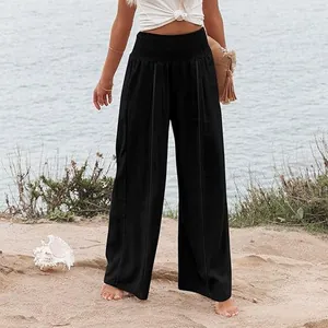 Pantalon décontracté noir pour femme à taille haute smockée et jambes larges sur la plage