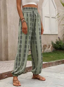 Detail of green geometric print lantern pants with high elastic waist and drawstring.