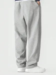 Detailed close-up of loose grey men's joggers featuring a casual floor-length hem design.