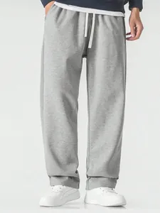 Detailed view of grey loose sports leisure pants with white drawstring and elastic waist.