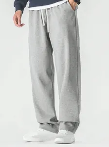 Detailed view of men's loose grey sweatpants featuring a comfortable wide-leg fit and soft fabric