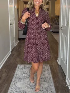 Detail view of a V-neck nine-point sleeve dress with burgundy diamond pattern