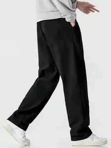 Detailed side view showing the drape of men's loose black casual sports pants with wide leg design