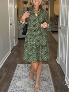 Detailed view of the V-neck and diamond digital print pattern on the green dress.