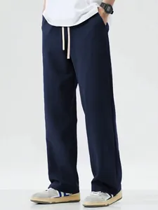 Full length view of men's loose navy blue wide-leg casual drawstring sports pants