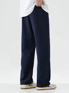 Rear view detail of loose dark navy blue men's sports casual trousers with floor-length fit