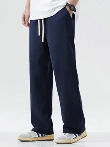 Detail view of navy blue men's loose-fit wide-leg floor-length casual sweatpants.