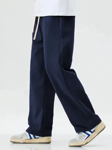 Detailed shot of men's navy blue loose-fit floor-length drawstring sweatpants style