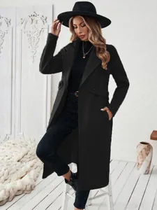 Élégant long manteau en laine noir à revers avec un chapeau et des bottes assortis