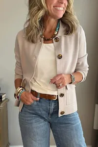 Femme d'âge mûr portant une veste courte beige à revers avec boutons en écaille et jean bleu