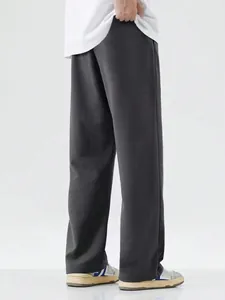 Rear view of loose fit grey wide-leg trousers for men in a minimalist casual sports style