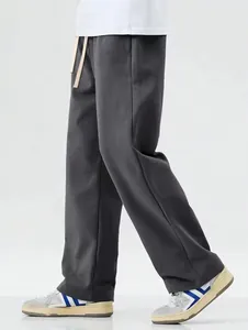 Detail side view of men's loose grey wide-leg trousers with adjustable drawstring waist