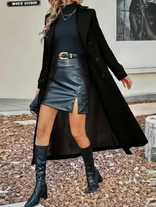 Detail view of a long black double-breasted wool coat styled with a leather skirt