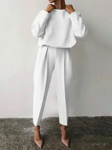 Elegante completo bianco da donna a due pezzi con top a maniche lunghe e pantaloni.