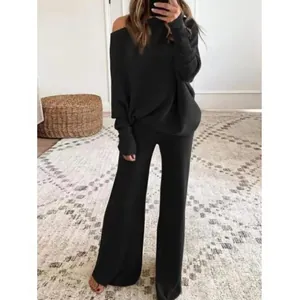 Selfie dans le miroir d'une femme portant un ensemble en tricot noir à manches chauve-souris.