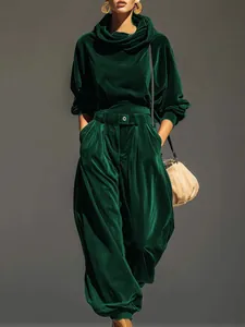 Detalle de la sudadera con capucha de terciopelo verde oscuro y el pantalón jogger a juego.