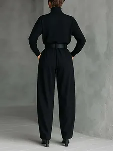 Back view of elegant black turtleneck long-sleeved top and high-waist wide-leg pants set with belt