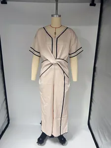 Combinaison rose clair élégante avec col en V, bordures noires et nœud à la taille